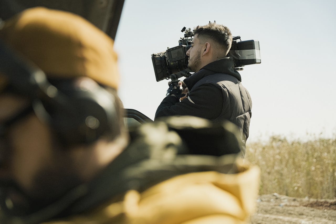 about-us-02 Cameraman recording in an outdoor rural area with professional equipment.